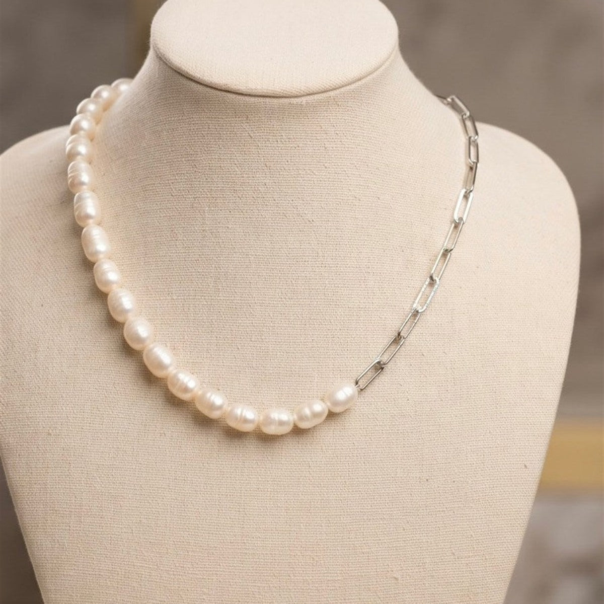 Half pearl, half chain freshwater pearl necklace on a display bust