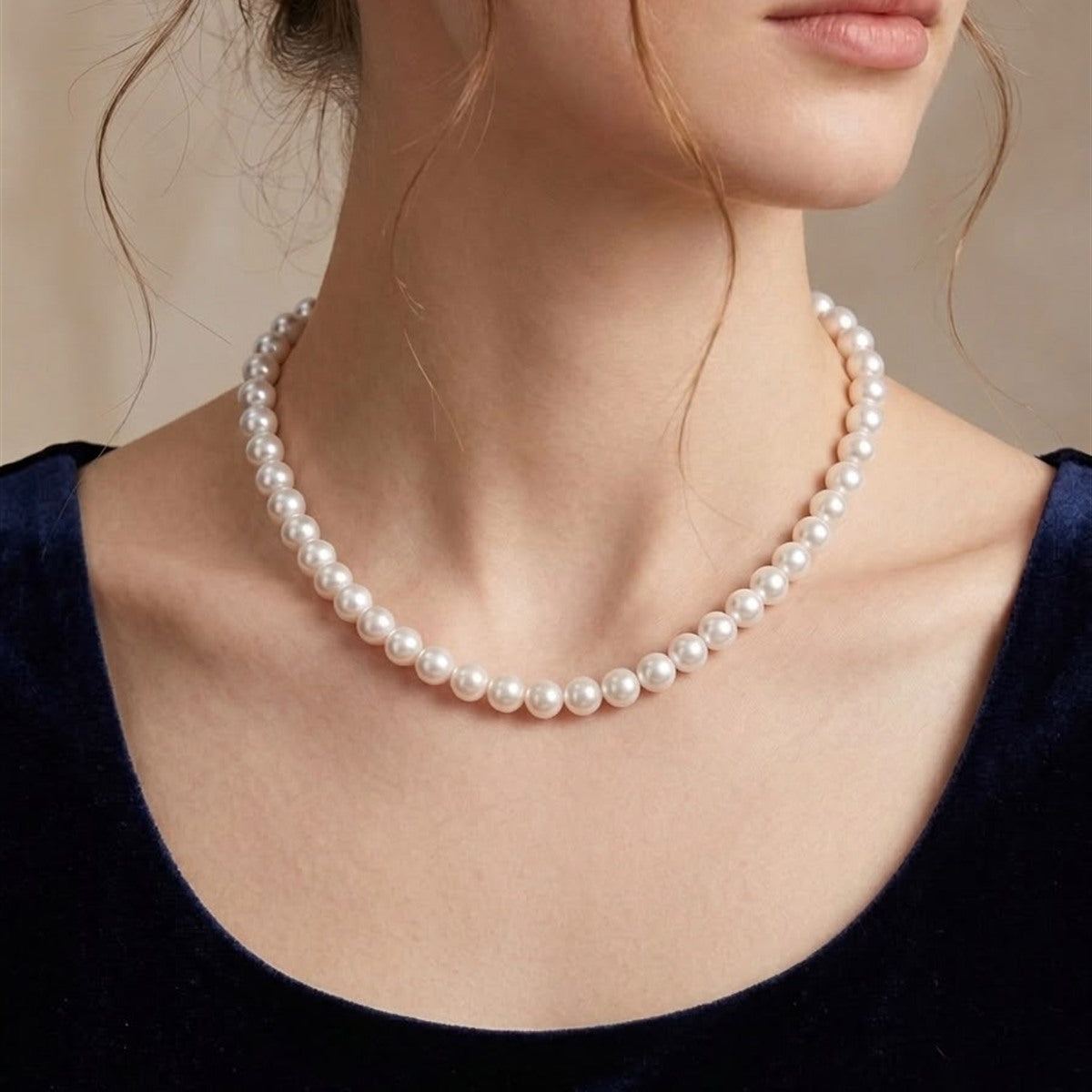 Classic white Akoya pearl necklace worn with a navy top