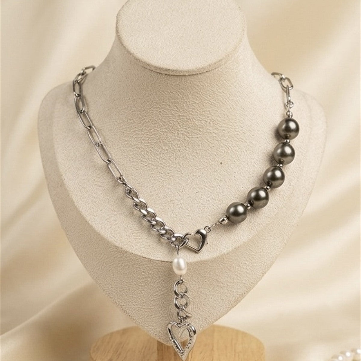 Tahitian pearl and heart charm chain necklace on a display bust