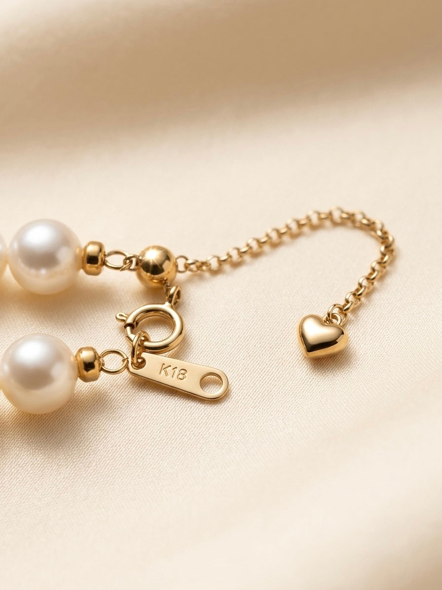 Close-up of the 18k gold clasp and heart extender on the multicolour Akoya pearl necklace