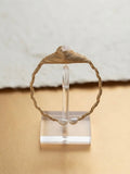 Twisted gold wire pearl cuff on a clear display stand
