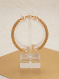 Woven gold triple pearl cuff on a clear display stand