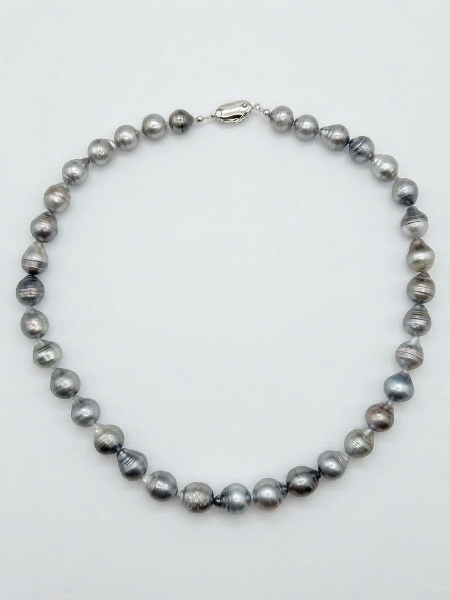 Baroque Tahitian pearl necklace laid flat on a white background