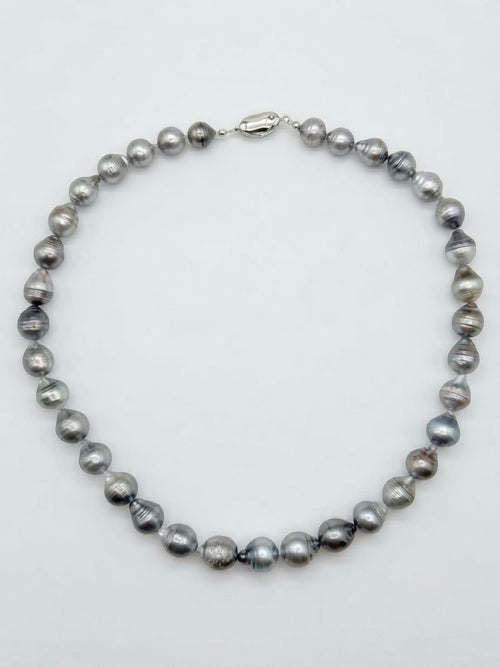 Baroque Tahitian pearl necklace laid flat on a white background
