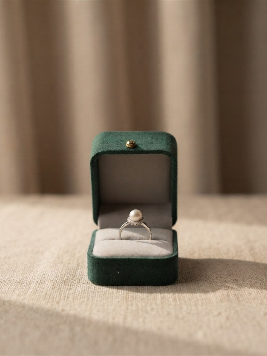 Akoya pearl halo ring in a green velvet ring box