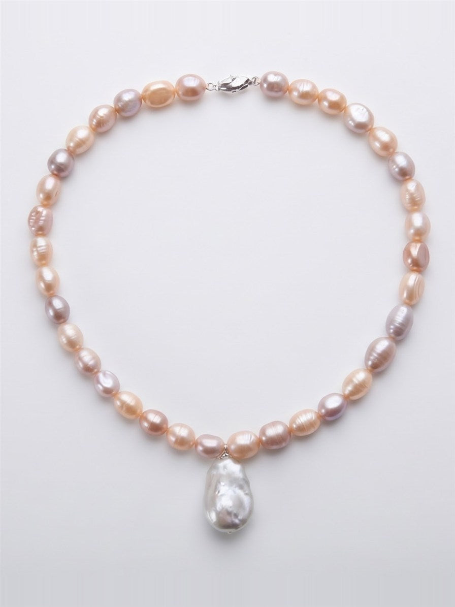 Pastel pearl necklace with large white baroque pearl drop on white background