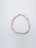 Pastel baroque pearl necklace with silver clasp on white background