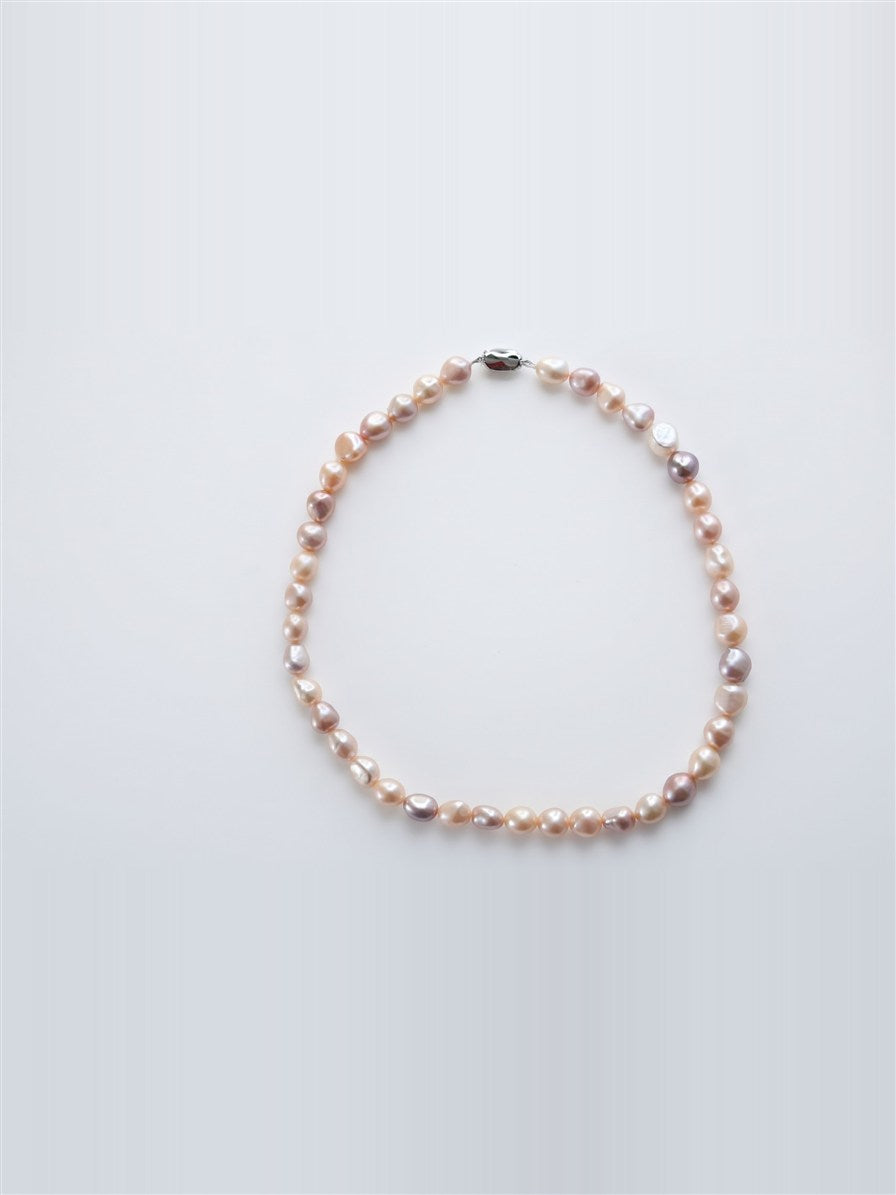 Pastel baroque pearl necklace with silver clasp on white background