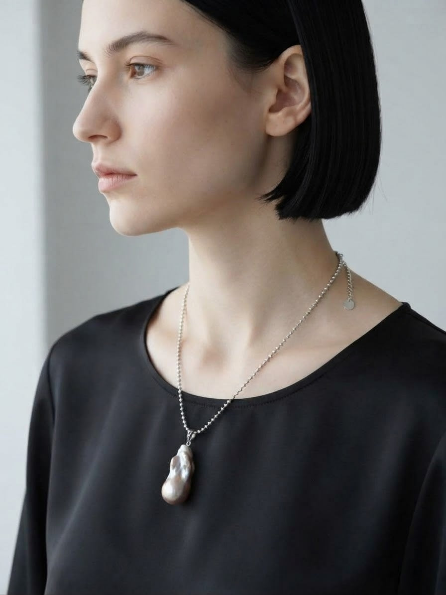 Baroque pearl pendant necklace worn with a black top