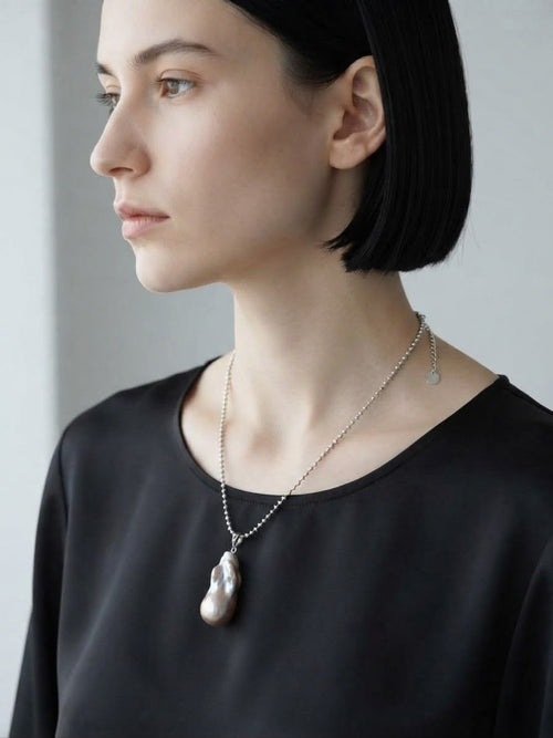 Baroque pearl pendant necklace worn with a black top
