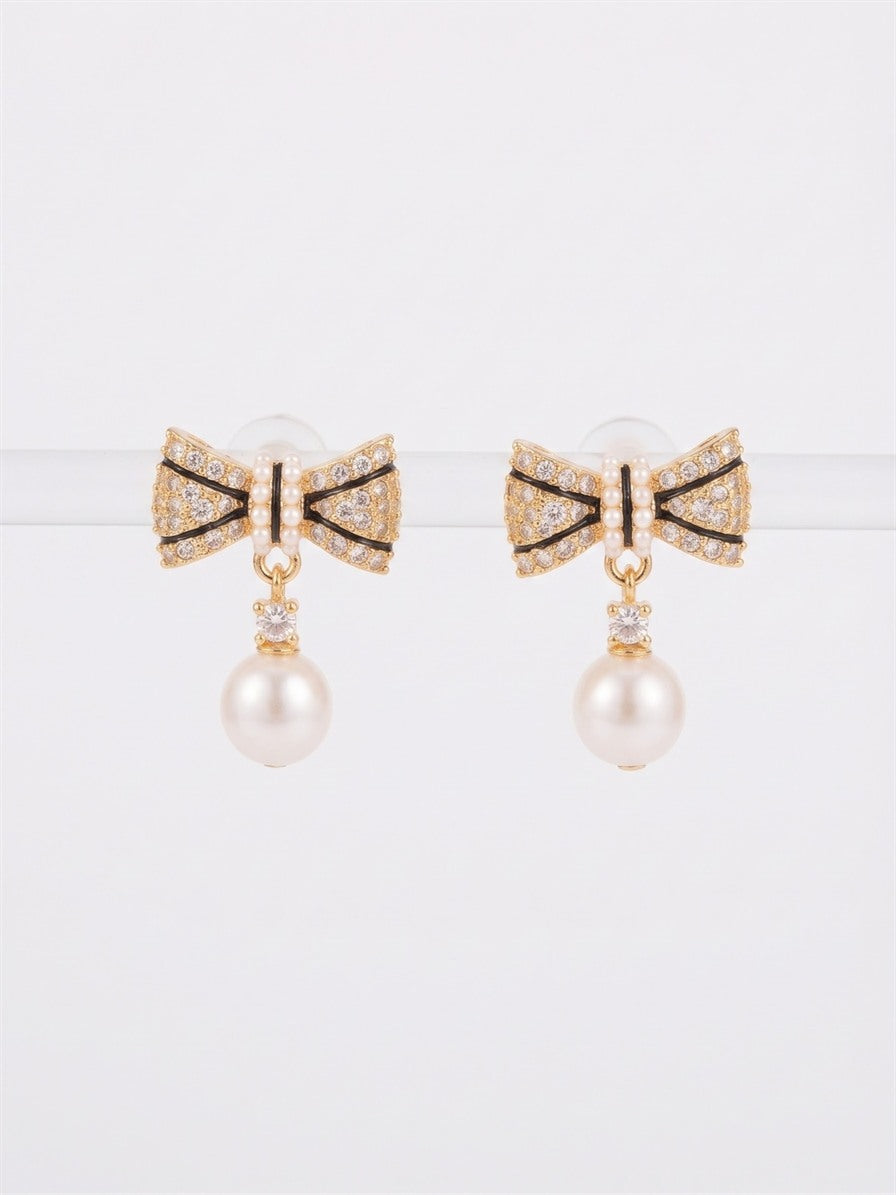 Gold-tone sparkling bow earrings with black enamel lines and freshwater pearl drops