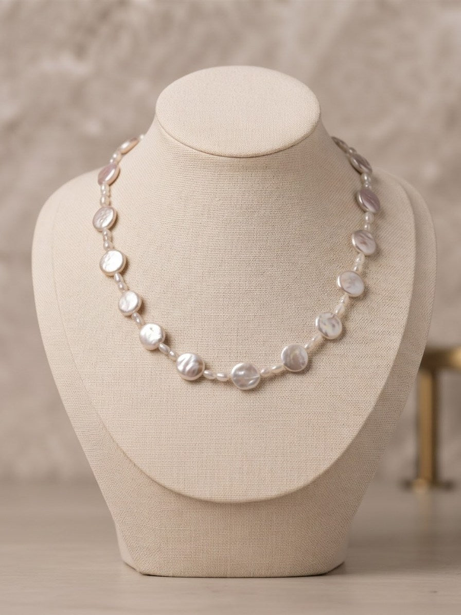 Freshwater coin pearl necklace on a linen display bust