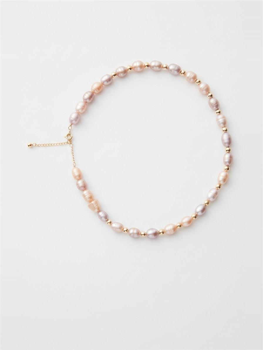 Pastel pearl and gold bead necklace with extender chain on white background