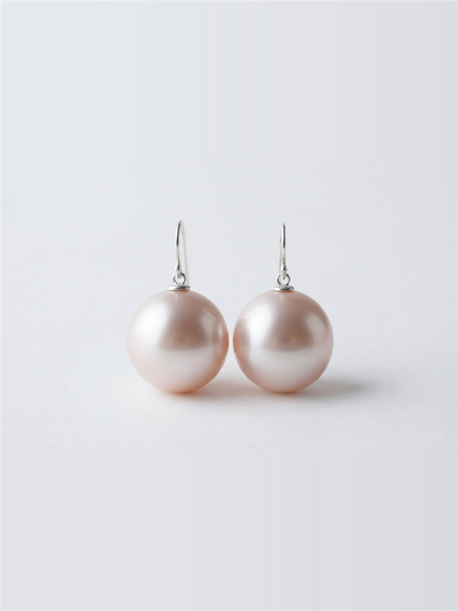 Large blush lavender pearl drop earrings on silver hooks, white background