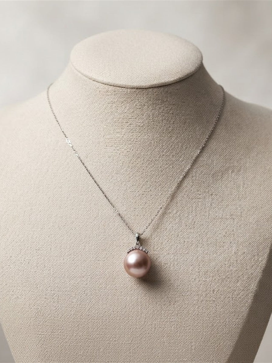 Lavender pearl crown pendant necklace on a linen display bust