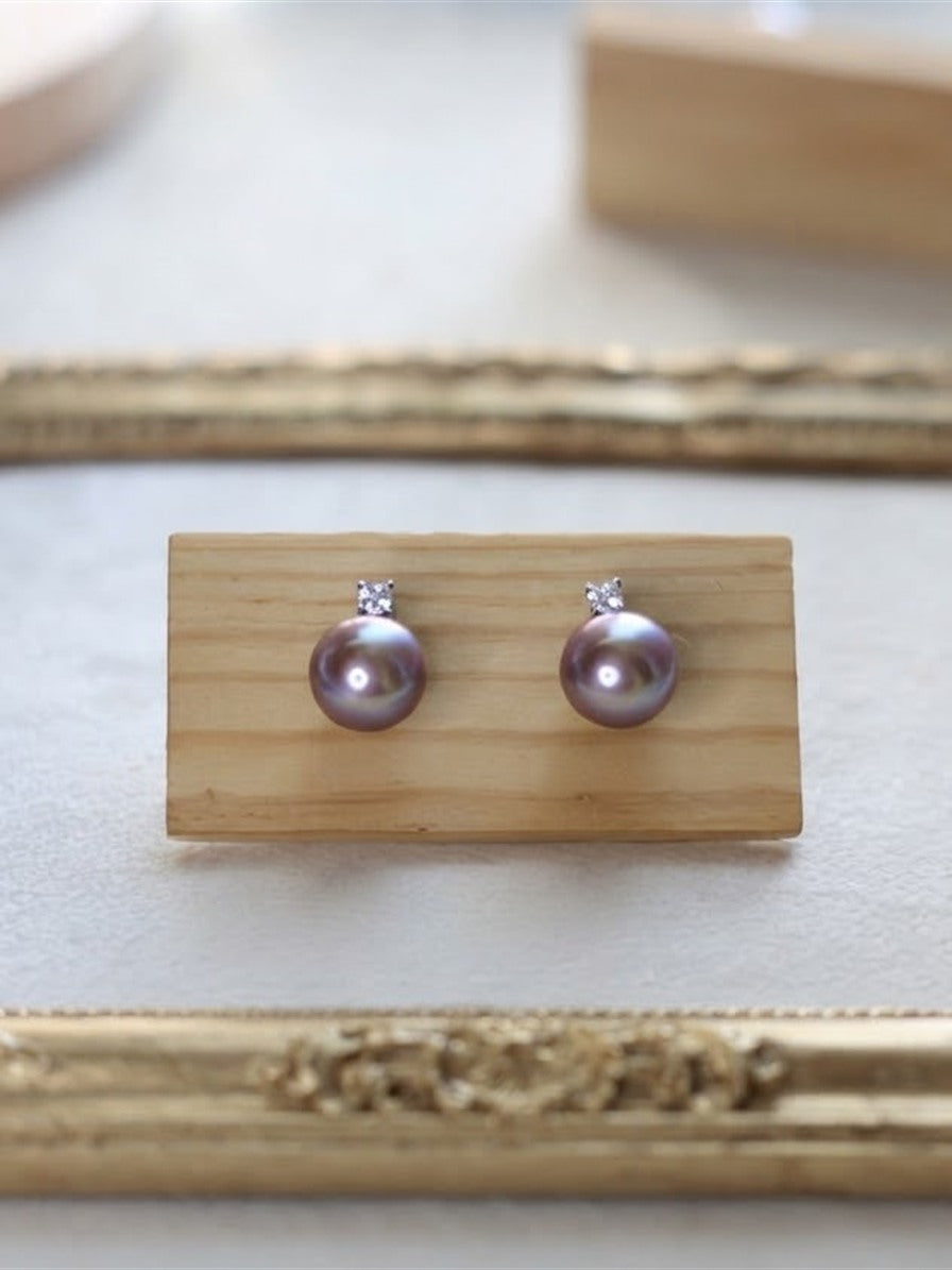 Lavender pearl solitaire stud earrings on a gold frame display
