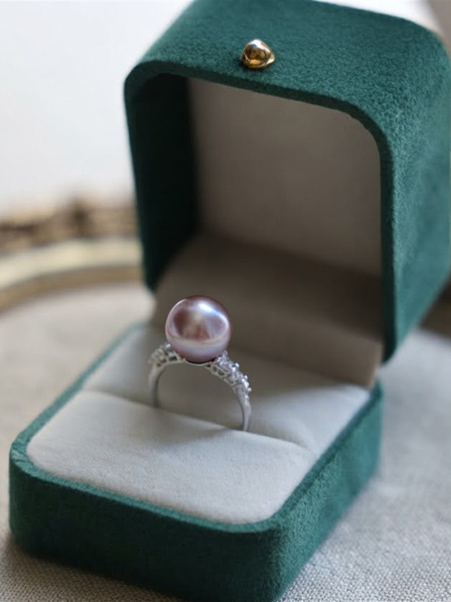 Lavender pearl ring with sparkling stone shoulders in a green velvet gift box