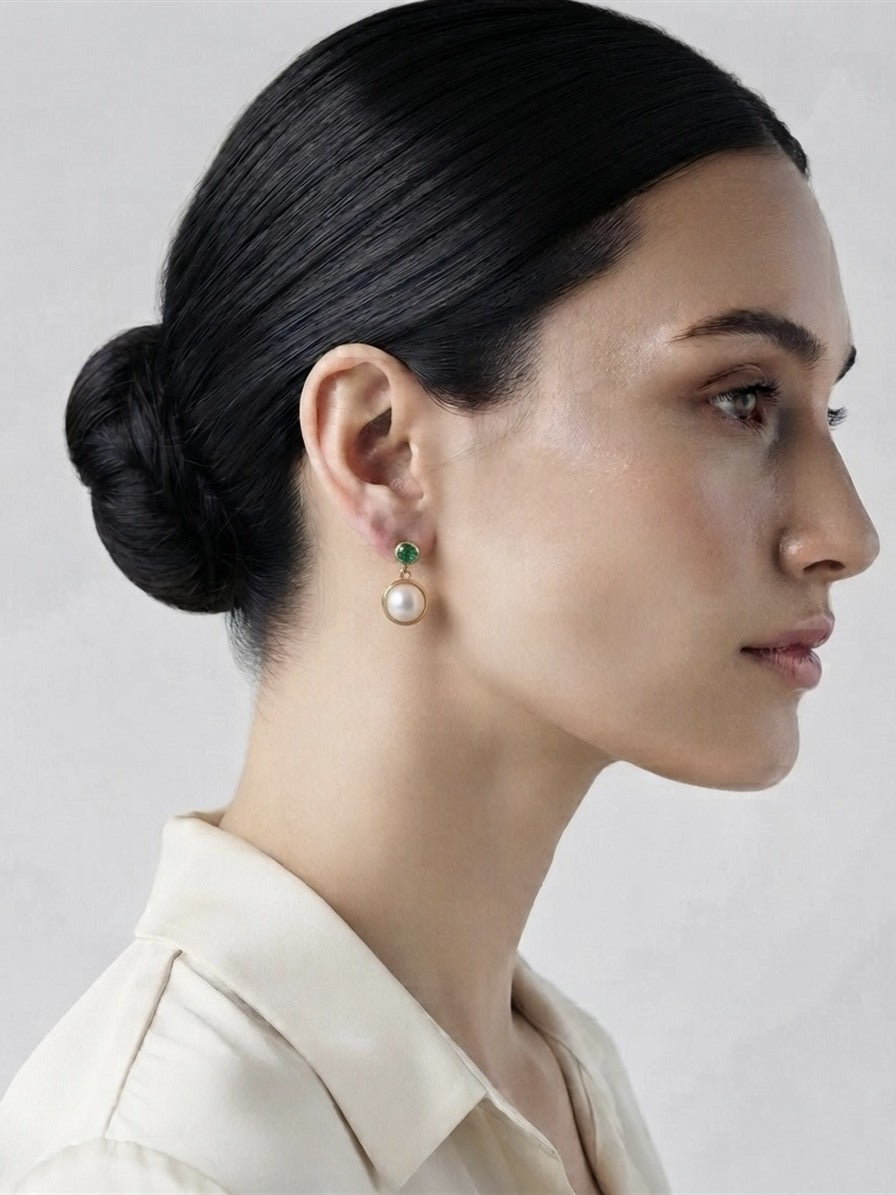 Mabe pearl and emerald earring worn with a cream shirt
