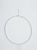 Dainty white freshwater pearl strand necklace with silver clasp on white background