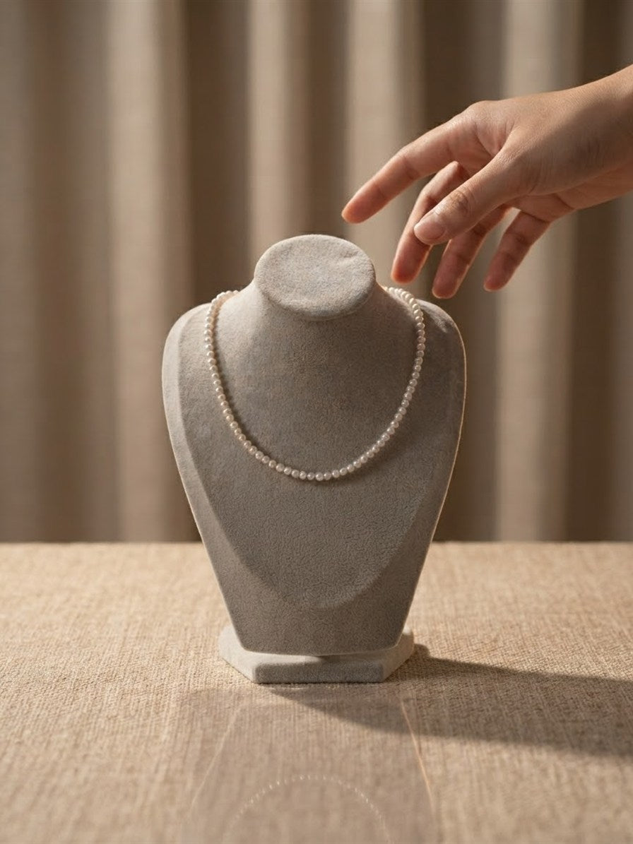 Dainty freshwater pearl necklace on a suede display bust