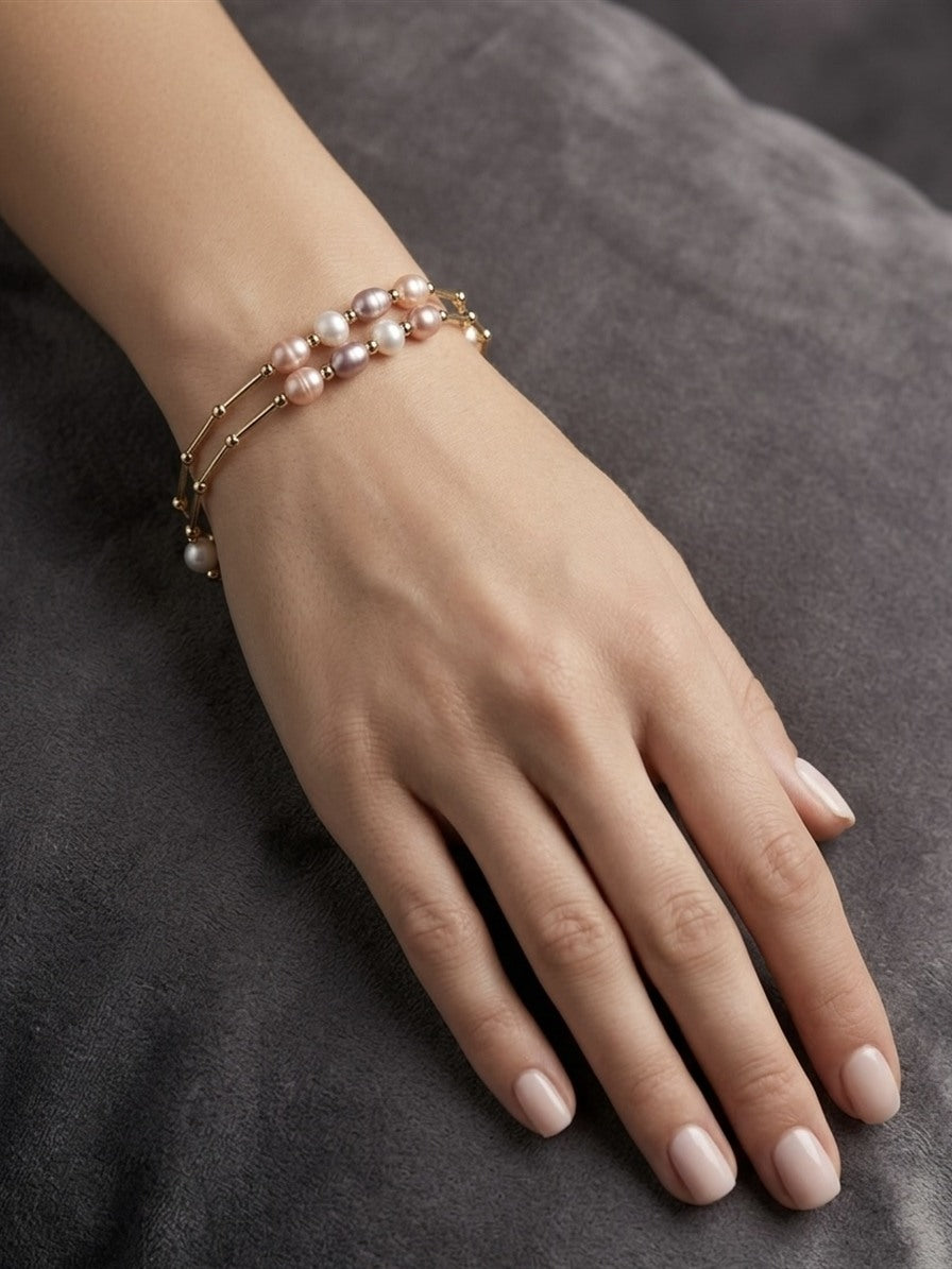 Multicolour freshwater pearl bar bracelet in gold-tone stainless steel worn on the wrist