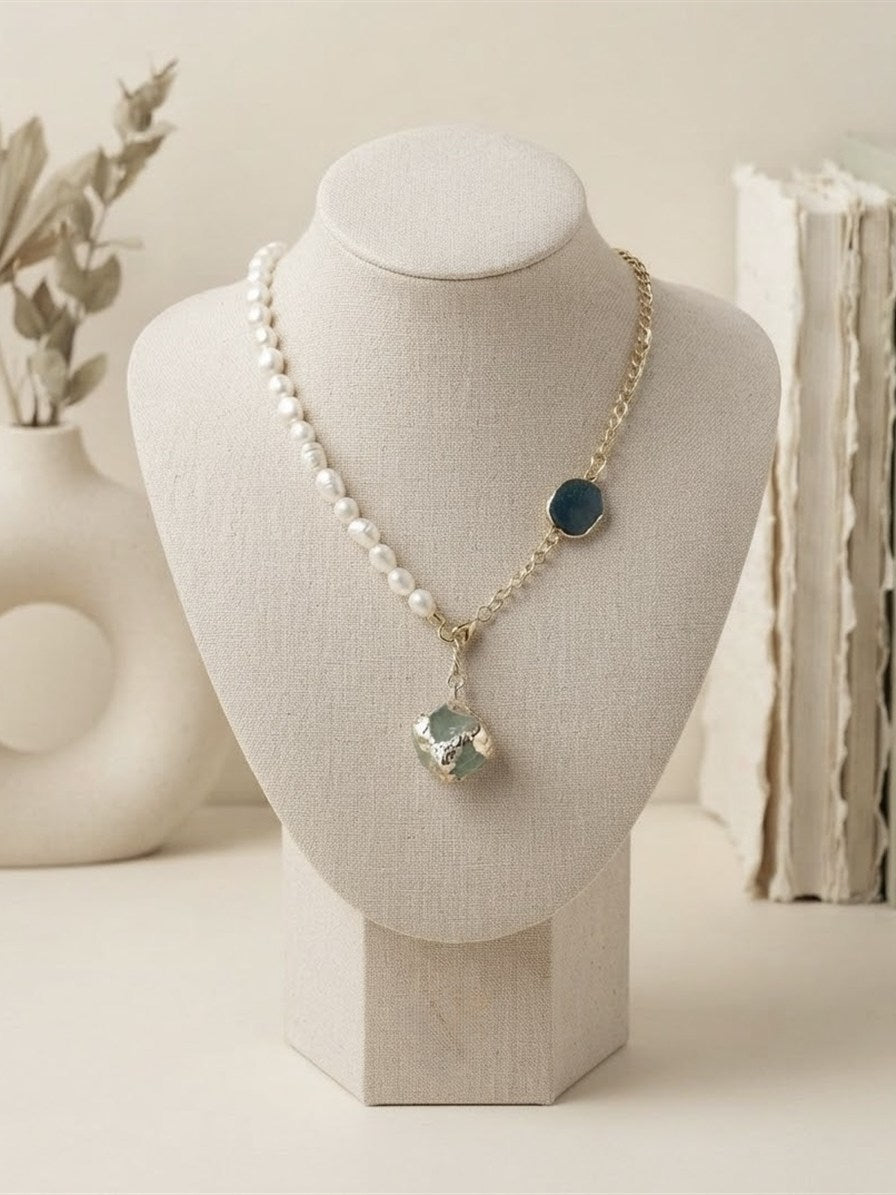 Freshwater pearl and gold chain necklace with blue and aqua raw stones on a linen bust