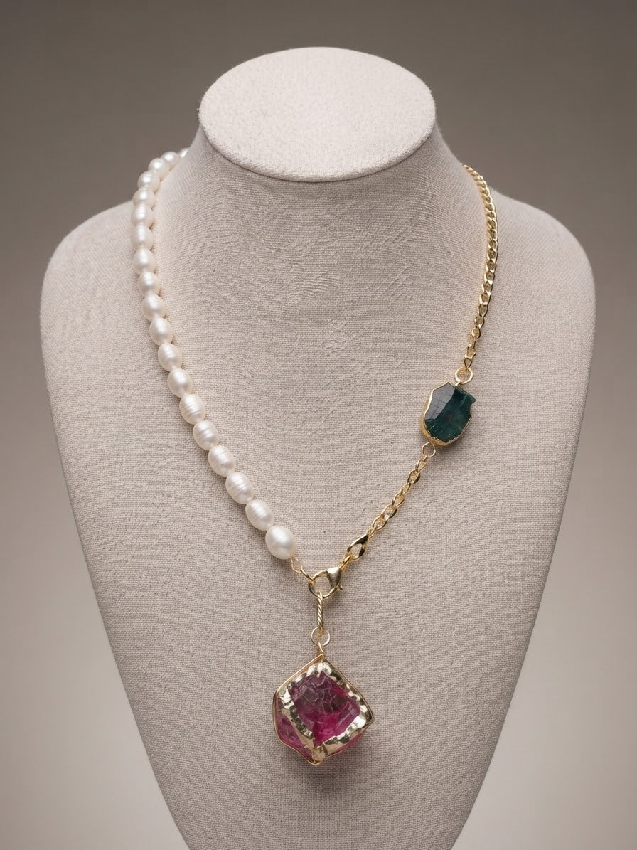 Freshwater pearl and gold chain necklace with raw pink and green stones on a display bust
