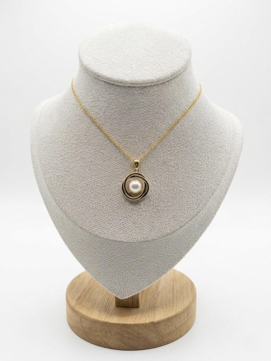 Love knot pearl pendant necklace in gold tone on a display bust