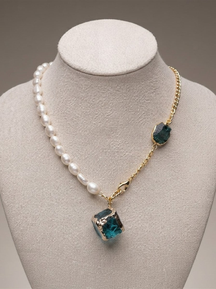 Freshwater pearl and gold chain necklace with teal and green raw stones on a linen bust