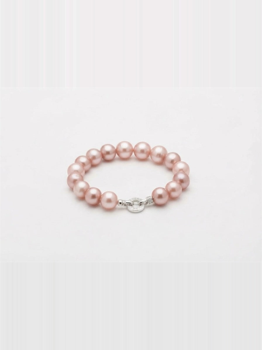 Pink freshwater pearl bracelet with sparkling round clasp on white background