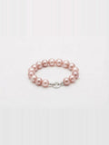 Pink freshwater pearl bracelet with sparkling round clasp on white background
