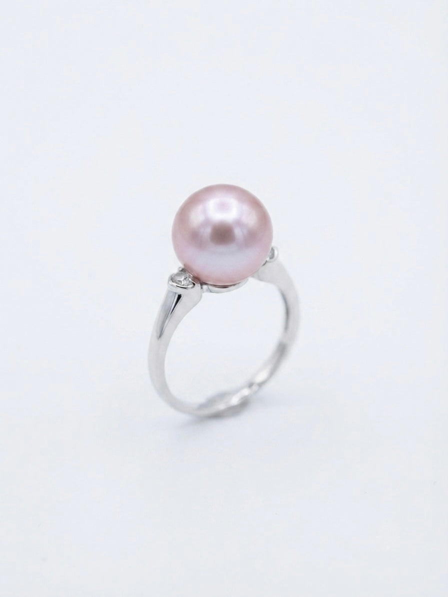 Lavender pearl ring with sparkling accent stones on a white background
