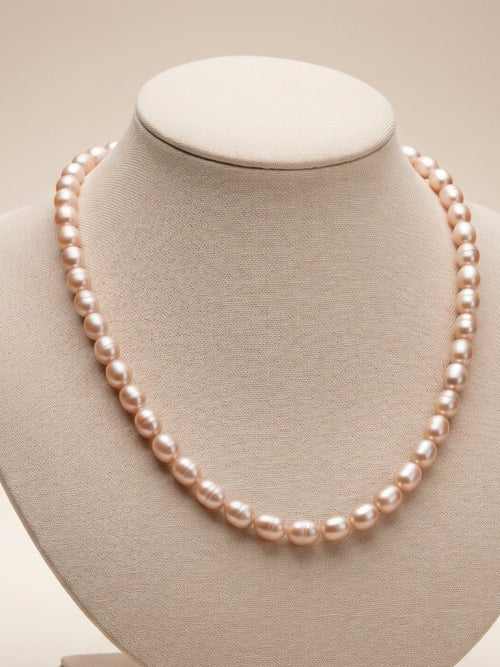 Blush lavender rice pearl necklace on a linen display bust