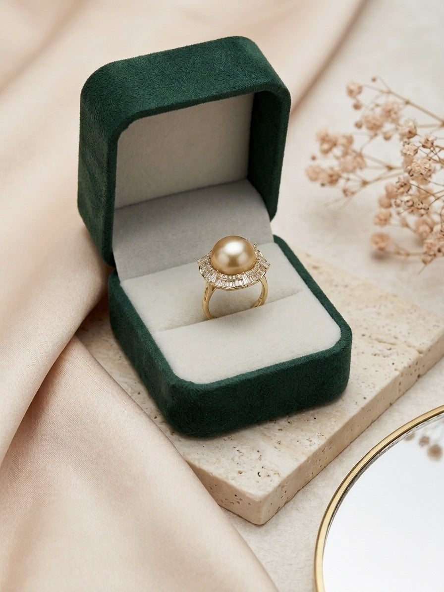Golden South Sea pearl ring with a baguette-stone halo in a green velvet box