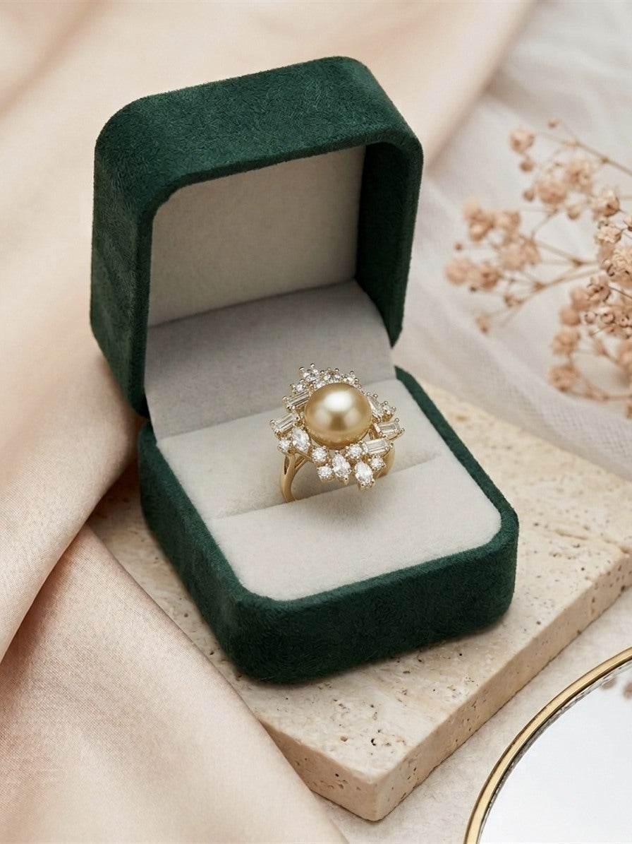 Golden South Sea pearl ring with a starburst cluster of sparkling stones in a green velvet box