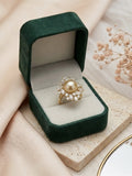 Golden South Sea pearl ring with a starburst cluster of sparkling stones in a green velvet box