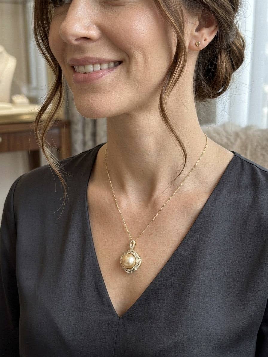 Golden South Sea pearl halo pendant worn with a charcoal V-neck top