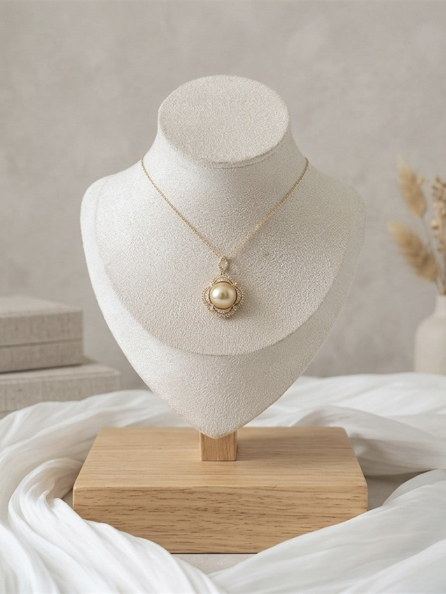 Golden South Sea pearl halo pendant on an ivory display bust