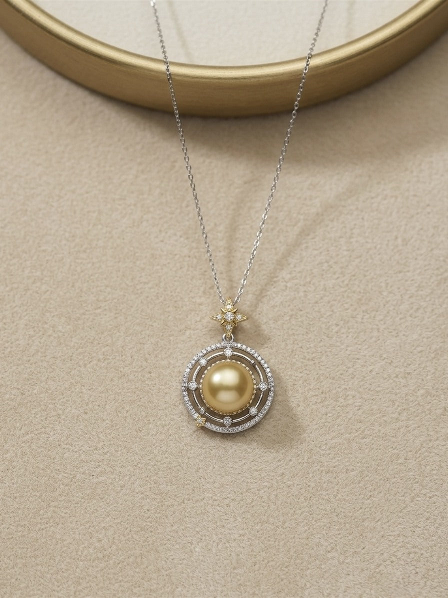 Golden South Sea pearl star orbit pendant on a beige suede display