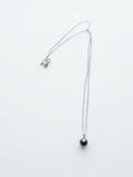 Chocolate Tahitian pearl pendant on a silver chain, white background