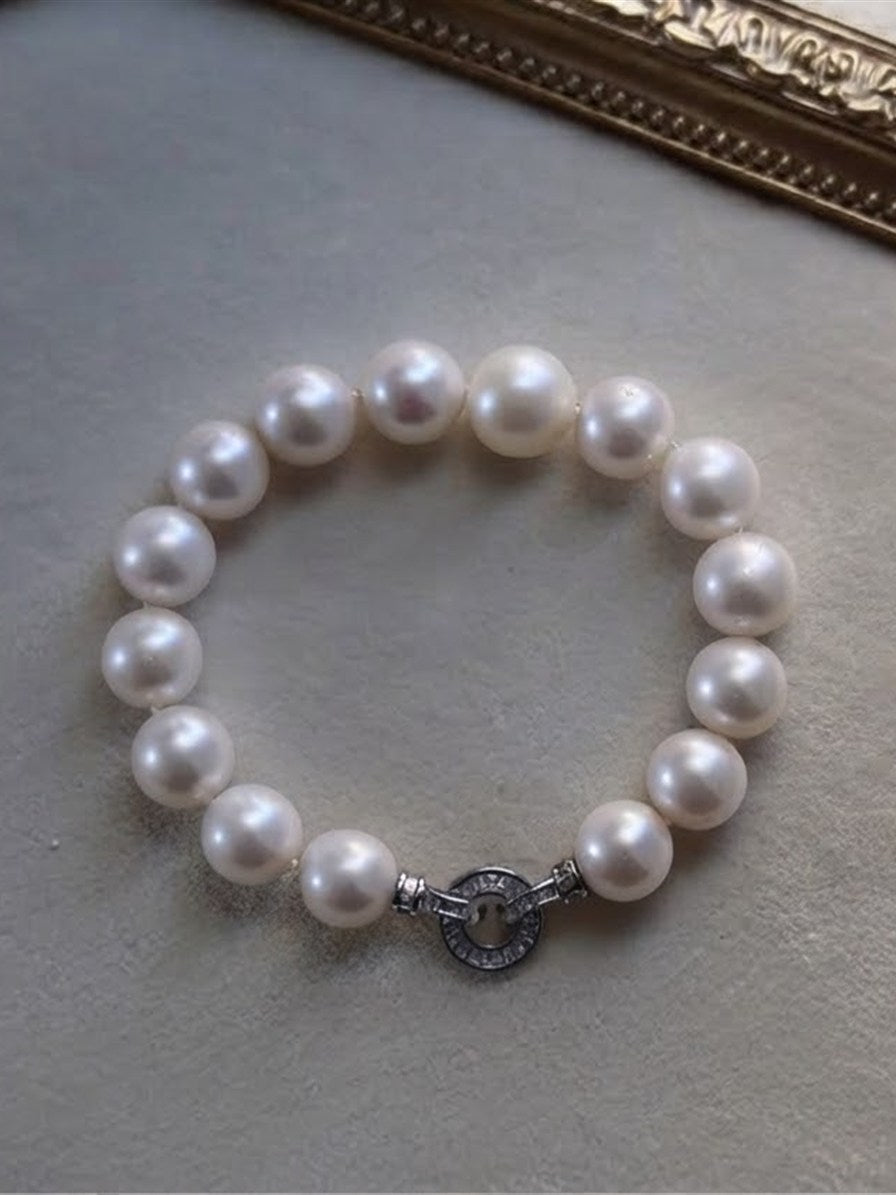 White freshwater pearl bracelet displayed on a velvet tray